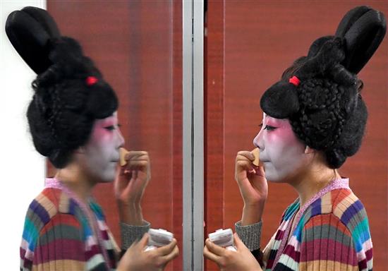 ?郑州歌舞剧院的演员在化装（2月20日摄）。